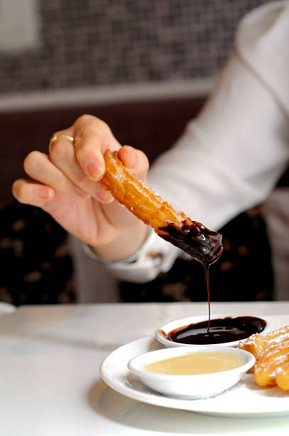 istock hand dipping Spanish churros to warm dark chocolate sauce 494740089