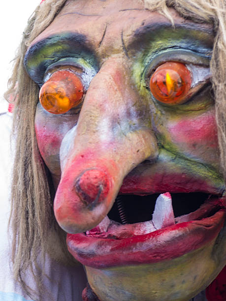 Portrait of Witches Ursula at Cerknica carnival Slovenia Cerknica, Slovenia - February 15, 2015: Front view, portrait of the witches Ursula. She has red eyes with yellow light, red lips, vampire teeth and long nose. In background is light sky. She Is on street in Cerknica during carnival time. cerknica lake stock pictures, royalty-free photos & images