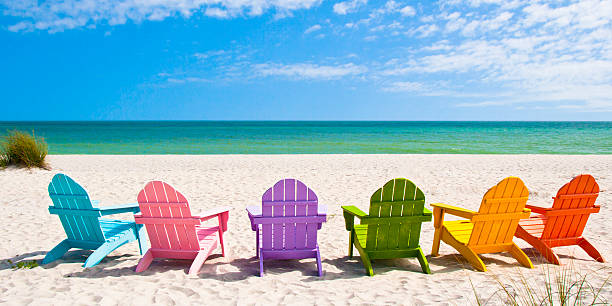 Adirondack Beach Chairs on a Sunny Vacation Beach Adirondack Beach Chairs on a Sun Beach in front of a Holiday Vacation Travel house sanibel island stock pictures, royalty-free photos & images