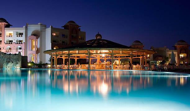 Stepping stones over an outdoor swimming pool at night. There is strong daylight from the left illuminating the steps.