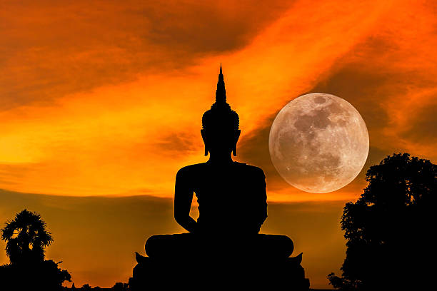 istock silhouette big buddha statue on sunset with full moon 494753080