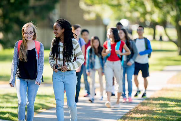 Friends Walking to Class A multi-ethnic group of high school age students are walking to class together before school. secondary school activities stock pictures, royalty-free photos & images