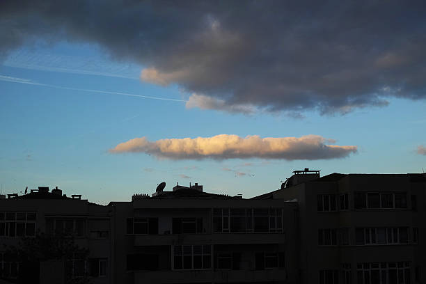 blue sky entre des nuages sombres et silhouette de la ville - hoirzontal photos et images de collection