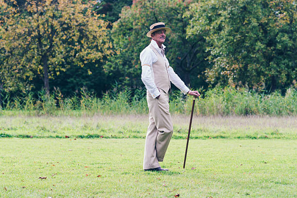 Dandy standing with cane on lawn in garden.