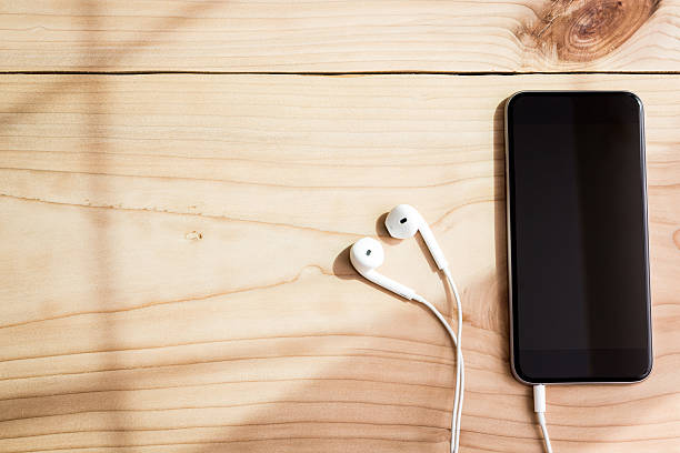 istock phone and headphone on wood background 494756744
