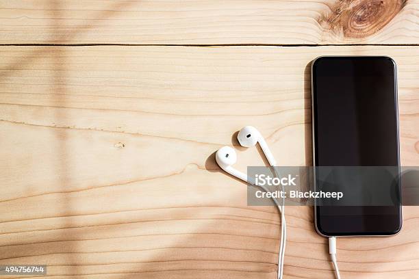 Phone And Headphone On Wood Background Stock Photo - Download Image Now - Desk, Headphones, Smart Phone