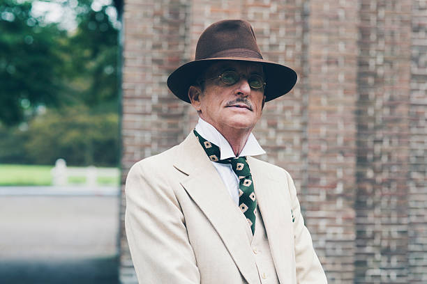 istock Senior dandy with hat and glasses in front of gate. 494757112
