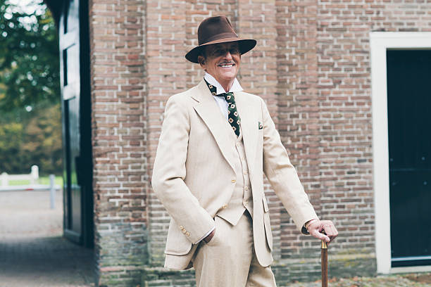 istock Smiling senior dandy standing with cane in front of gate. 494757158