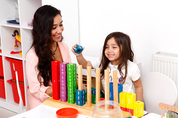 istock Young teacher playing with cute little girl 494757514