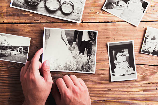 Wedding photos on a table Wedding photos laid on a table. Studio shot on wooden background. wedding photos stock pictures, royalty-free photos & images