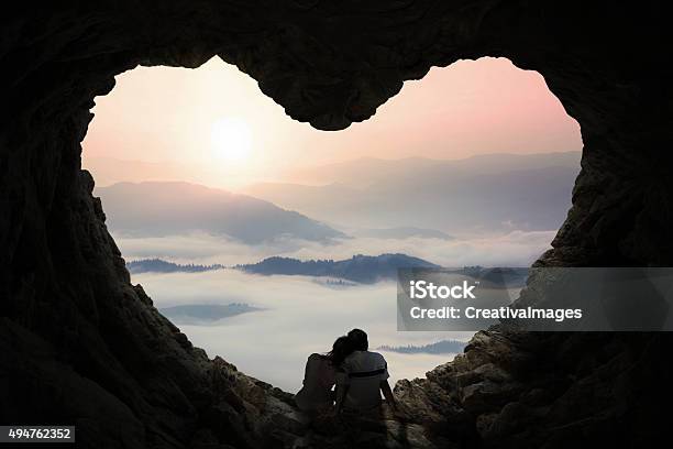 Pareja Romántica Disfrutar De La Vista A Las Montañas En Cave Foto de stock y más banco de imágenes de Amor - Sentimiento