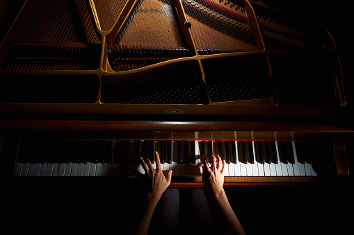Woman's hands on the keyboard del piano en la noche photo