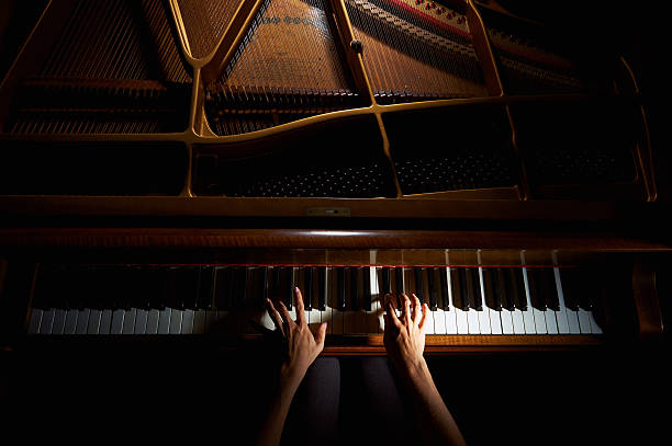 femme les mains sur le clavier du piano dans la nuit - piano photos et images de collection