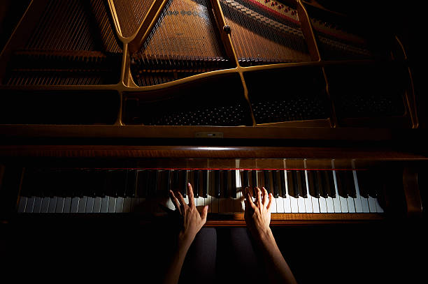 donna le mani sulla tastiera del pianoforte a notte - pianoforte foto e immagini stock