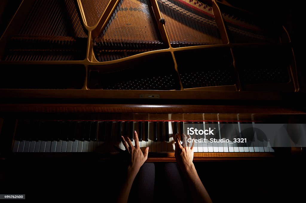 Woman's hands on the keyboard of the piano in night Woman's hands playing on the keyboard of the piano in night closeup Piano Stock Photo