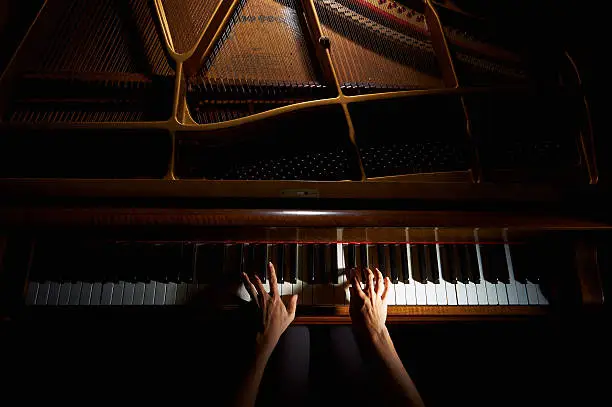 Photo of Woman's hands on the keyboard of the piano in night