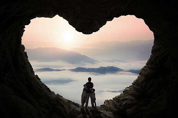 istock Two children hugging their father inside cave 494763024