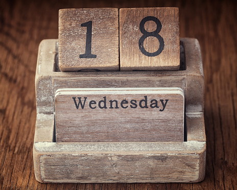 Grunge calendar showing Wednesday the eighteenth on wood background