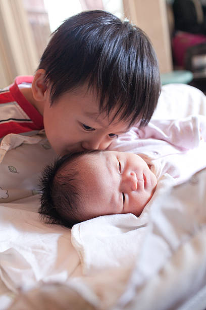 sweet boy kissing his sister stock photo