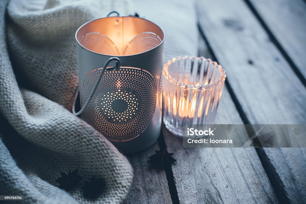 Cosy and soft winter background Cosy and soft winter background, knitted sweater and candles on an old vintage wooden board. Christmas holidays at home. Candle Stock Photo