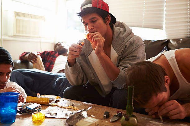 Gang Of Young Men Taking Drugs Indoors Gang Of Young Men Taking Drugs Indoors On Sofa bong photos stock pictures, royalty-free photos & images