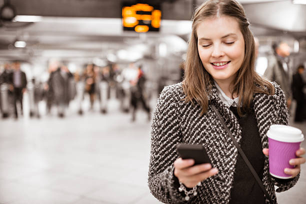 donna utilizzando un cellulare in metropolitana stazione della metropolitana - london england on the move commuter rush hour foto e immagini stock