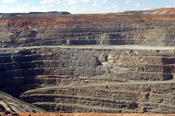 View of the giant crater of Kalgoorlie Gold Mine in Australia where huge machines seem so small at the bottom of this hole 1,200 meters deep