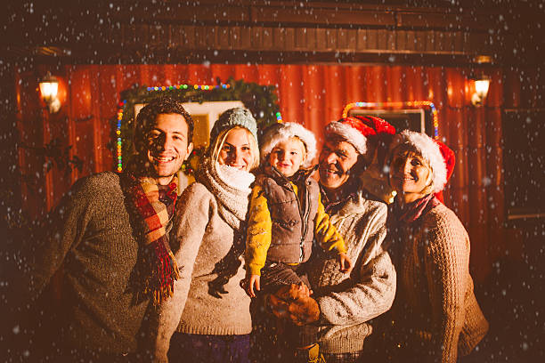 Family portrait on the first snow Portrait of a cute multi-generation family in the backyard greeting the first snow for the winter season  baby new years eve new years day new year stock pictures, royalty-free photos & images