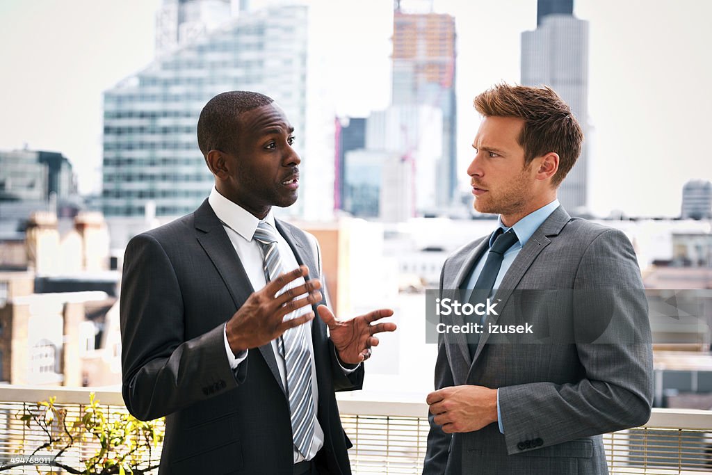 Business talk Two professional businessmen talking with a cityscape in the background. Bonding Stock Photo