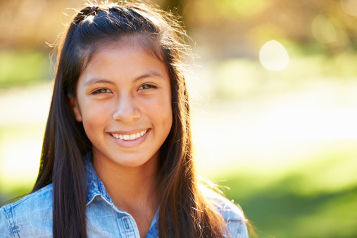 Portrait Of Hispanic Girl In Countryside Smiling To Camera