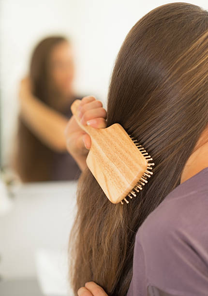 istock closeup on young woman combing hair 494780501