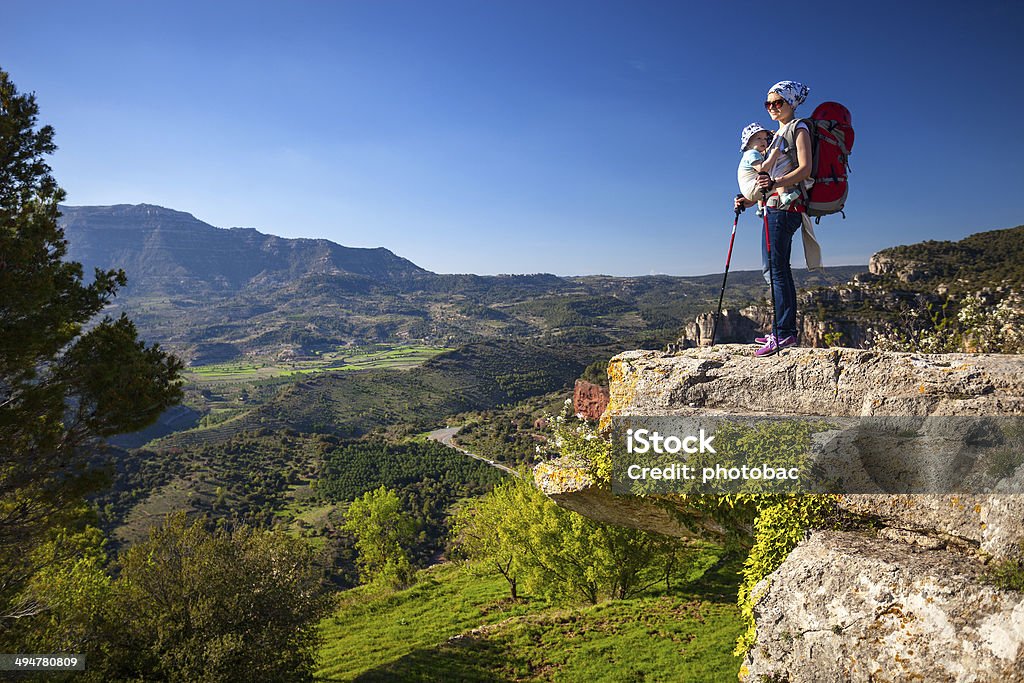 Hiker with baby relaxing on cliff and enjoying valley view Hiker with baby son relaxing on cliff and enjoying valley view Hiking Stock Photo