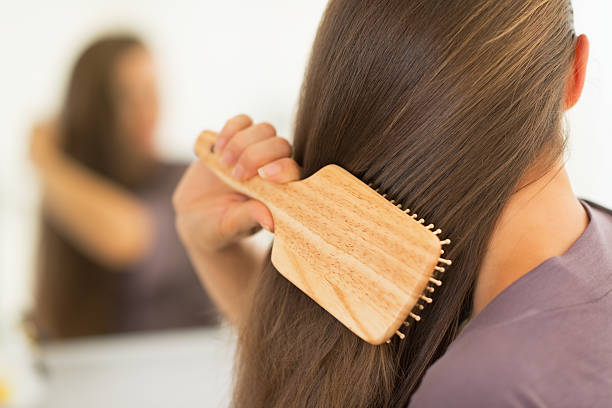 istock closeup on young woman combing hair 494780875