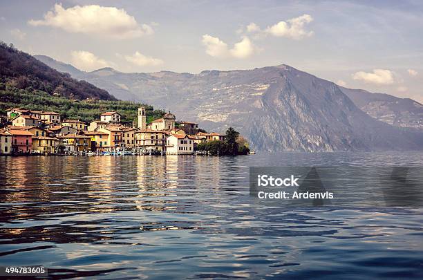 Porto E Montagne Riflette In Acqua Lago Diseo Monte Isola - Fotografie stock e altre immagini di Lago d'Iseo