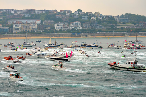 San Sebastian, Spain - September 9, 2012: Every September a rowing competition is hold at San Sebastian, Spain. Boats appearing belong to local citizens who watch the competition from their own boats.