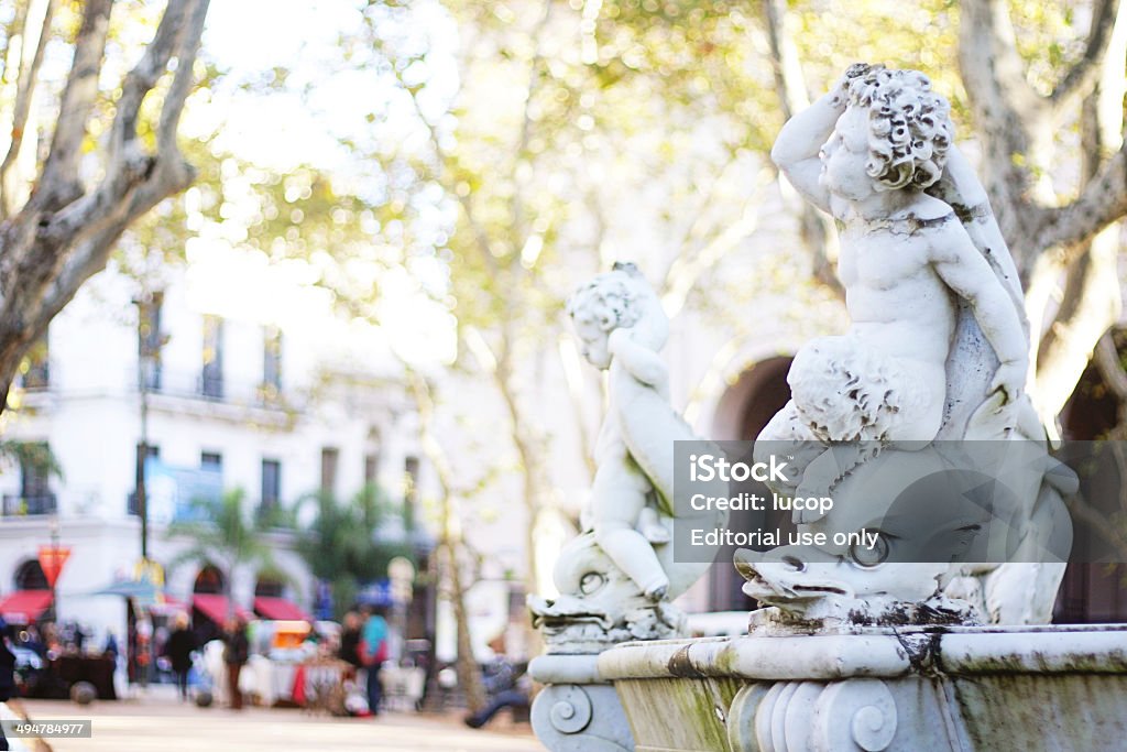 Cherubim on a dolphin in a fountain at Montevideo Montevideo, Uruguay - May 26, 2014: Fountain at the Constitución Square (also known as Plaza Matriz), main town square of the old colonial city. The fountain was constructed by the italian architect Juan Ferrari at 1871. Historic place where the promulgation of the first constitution occurred. Currently it is the tourist and commercial center of the neighborhood. Architecture Stock Photo