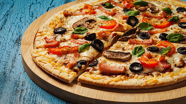 istock Ham pizza on blue wooden background 494787108