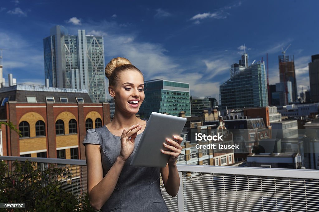 Attractive Businesswoman with digital tablet Portrait of professional businesswoman standing against cityscape and using a digital tablet. Adult Stock Photo