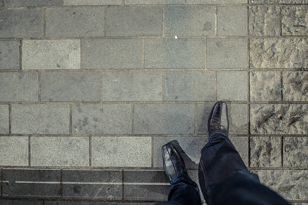 Looking down at dress shoes.
