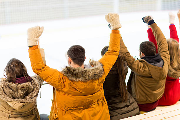 happy friends supporting team on ice rink arena