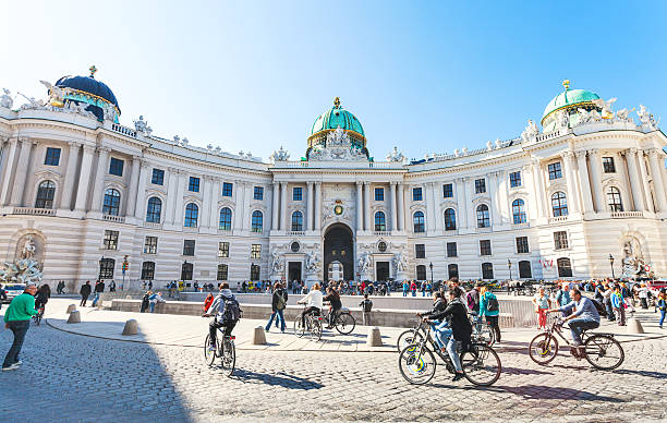 tourists on Michaelerplatz of Hofburg Palace Vienna, Austria - October 1, 2015: tourists on Michaelerplatz square of Hofburg Palace. Michaelertrakt (wing of the Palace) was completed at end of 19th century when old palace theatre was demolished the hofburg complex stock pictures, royalty-free photos & images