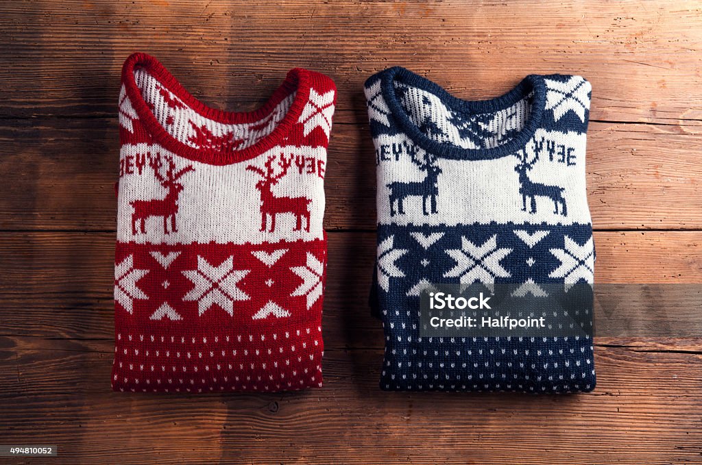 Two sweaters on a table Two winter sweaters laid on a wooden table background Sweater Stock Photo