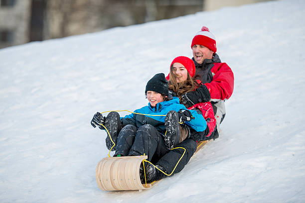 istock Family Tobogganing Down a Hill 494810106