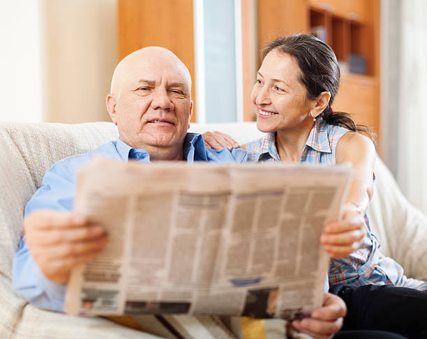 istock Happy mature couple reading newspaper 494811365