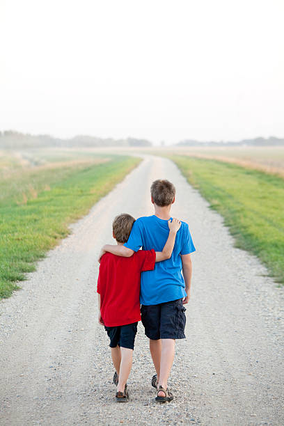 istock Two Boys Walking Down a Country Road 494811837