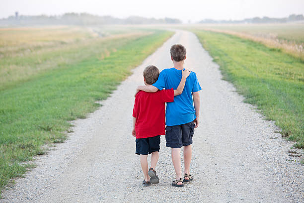 istock Two Boys Walking Down a Country Road 494811857