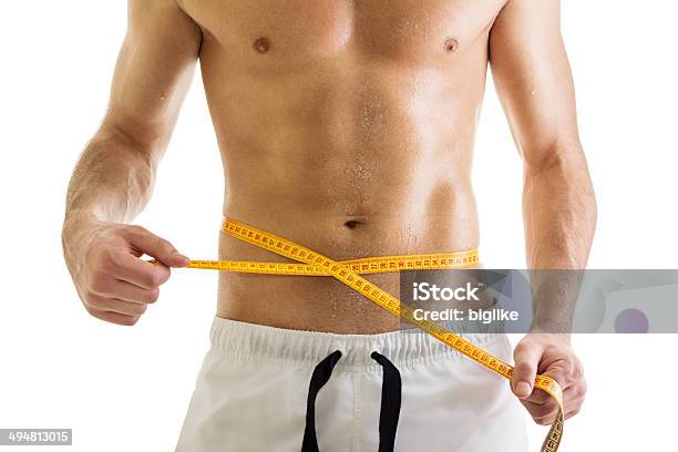 Fit Young Bodybuilder Hombre Medir Su Cintura Foto de stock y más banco de imágenes de Hombres - Hombres, Delgado, Cuerpo humano