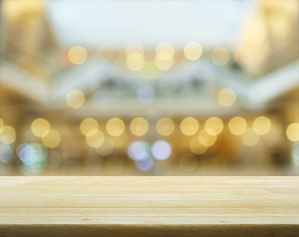 istock Empty wooden table over blurred mall bokeh background 494814396