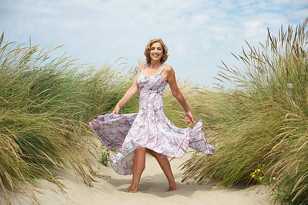 donna danza con la sabbia in spiaggia - one person beautiful barefoot beach foto e immagini stock