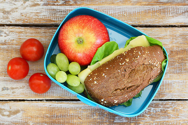 lunchbox aus wholegrain käse-sandwich, obst, kirschtomaten - lunch box lunch sandwich green stock-fotos und bilder